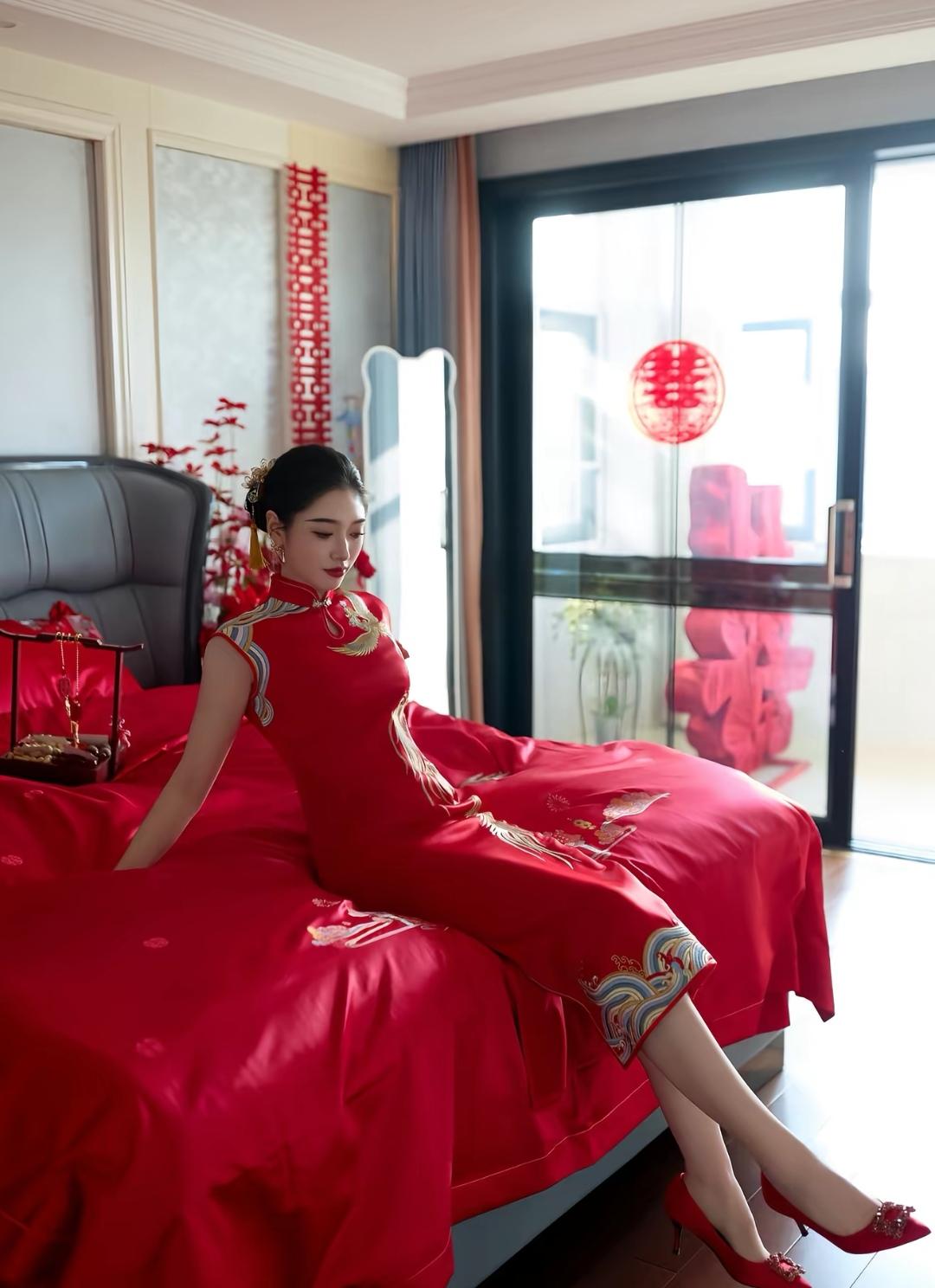 新娘穿着红色旗袍坐在床上，好喜庆！