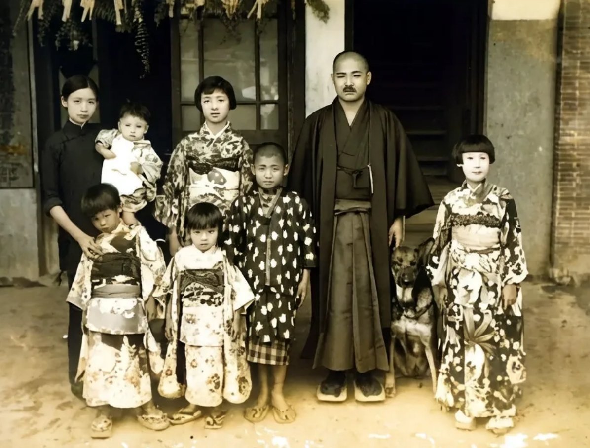 1934年，一户台湾人家新年合影，除站在后排角落的女子穿着中式服装外，其他都穿