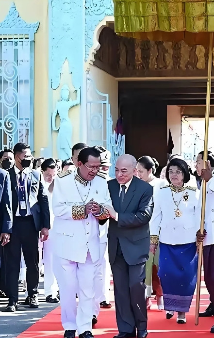 在近日的一次公开场合，西哈莫尼国王搀扶着洪森，然而洪森却志得意满地走在红地毯上。