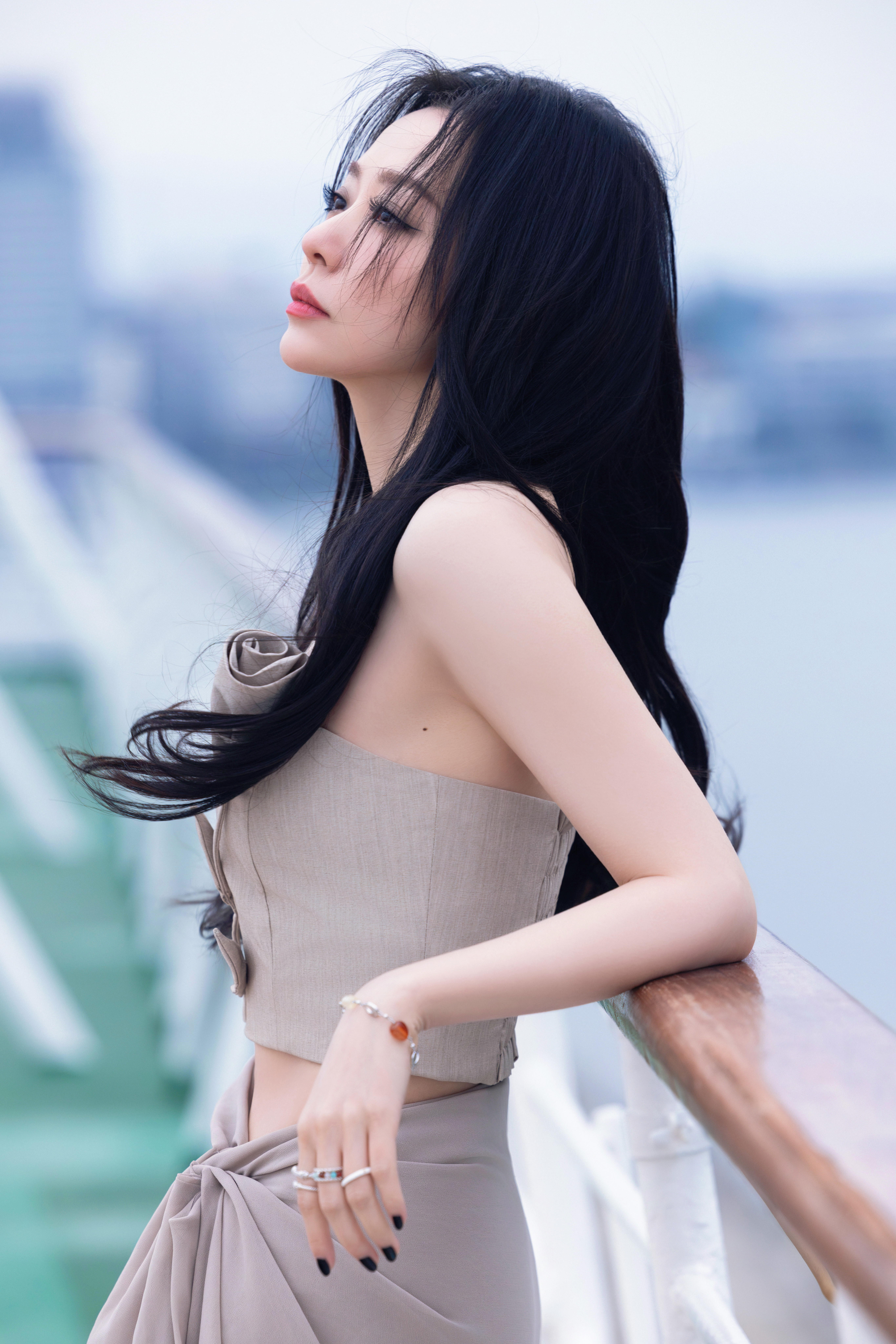 张靓颖微风轻拂发丝，与这身优雅穿搭相融，勾勒出独特的气质，在海天之间，美得静
