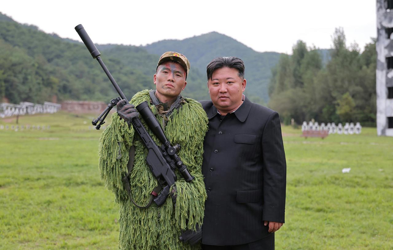 朝鲜狙击手手持朝鲜自己生产的新型狙击步枪同金正恩合影金正恩还就朝鲜国防科学院自
