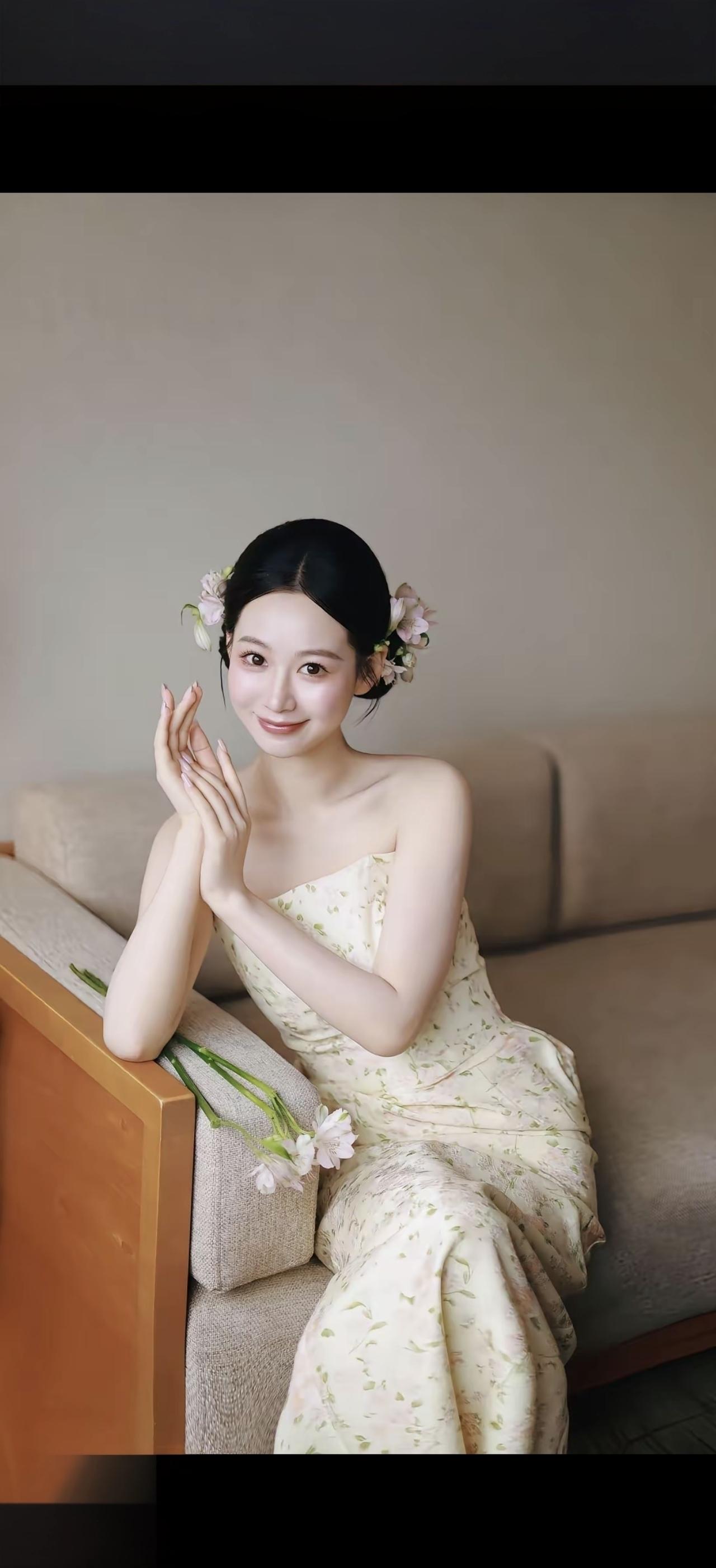 一个漂亮女孩坐在沙发上，手托着脸。