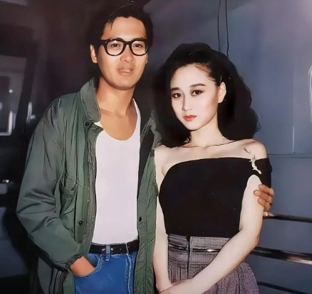 1987年，32岁的周润发与26岁的利智合影，周润发罕见带上了一副黑框眼镜，搂着