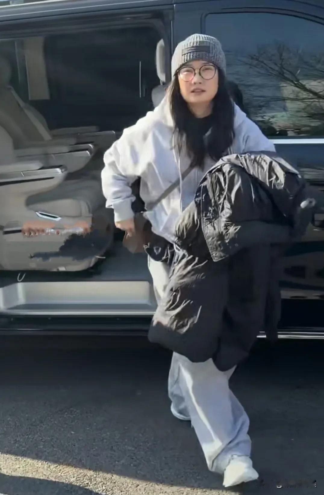 凤凰传奇的玲花现身春晚彩排，穿着一套灰色的休闲装，戴着羊毛帽和眼镜，步伐轻盈，久