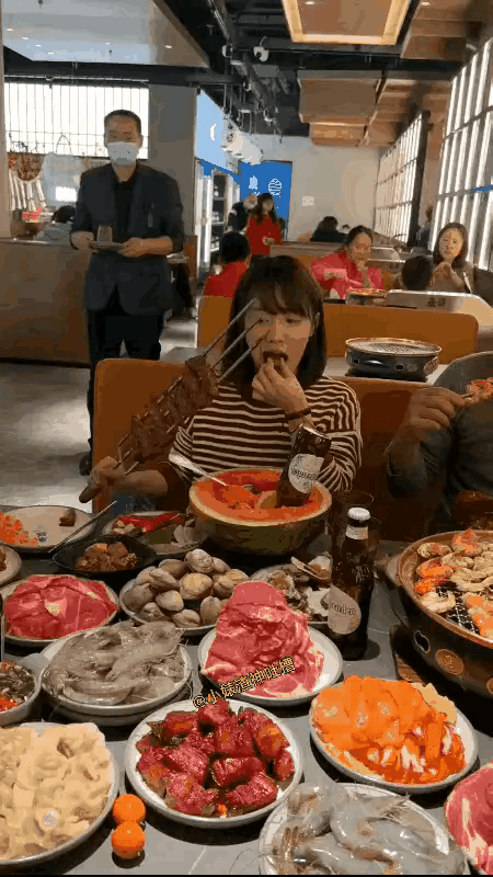 有这样吃自助餐的吗?这是一对情侣，在一家餐厅里，桌子上端了这么多菜，女子手里拿