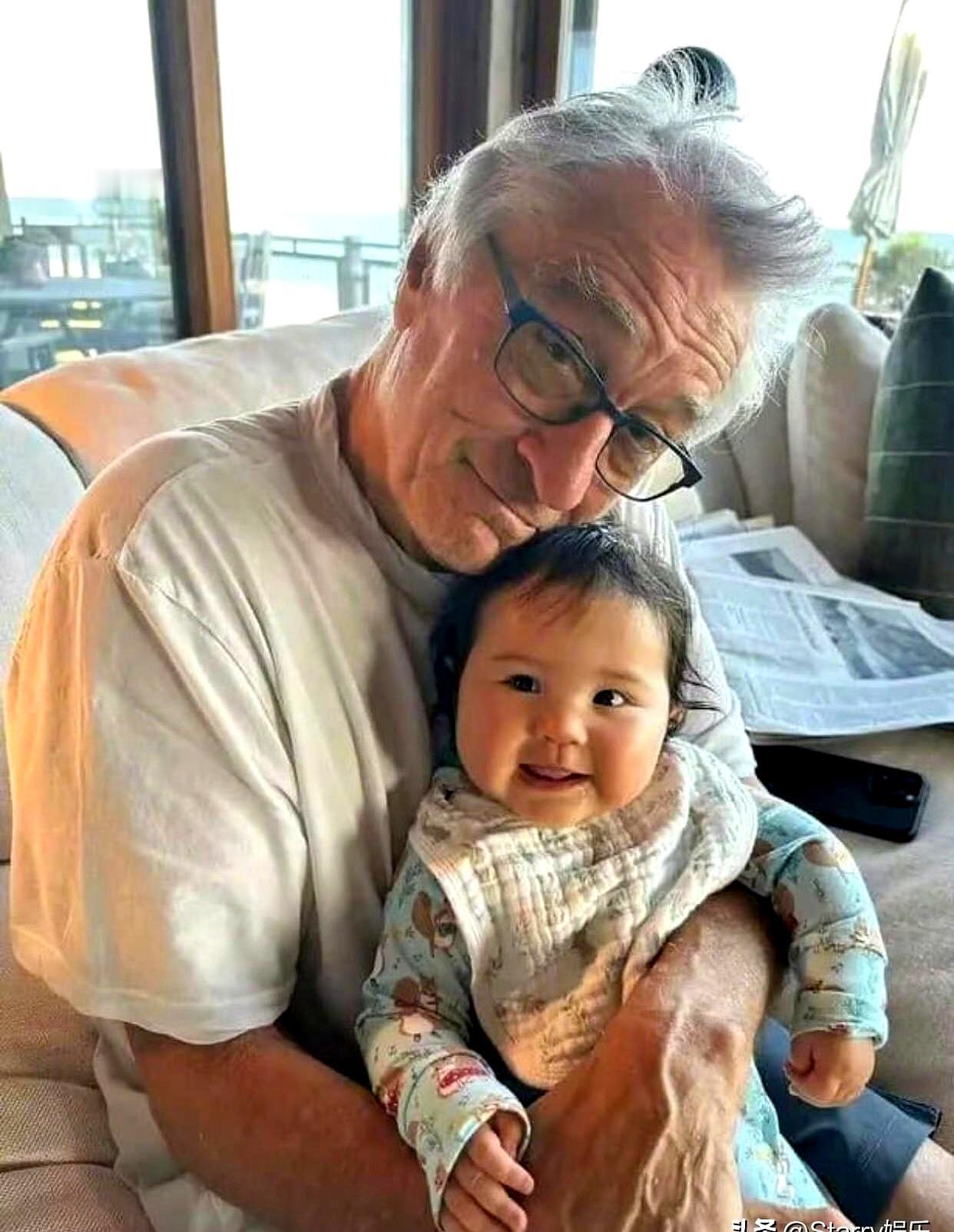 82岁德尼罗最近在公园被拍到，推着3岁女儿荡秋千，画面简直太治愈了。这老影帝，晚