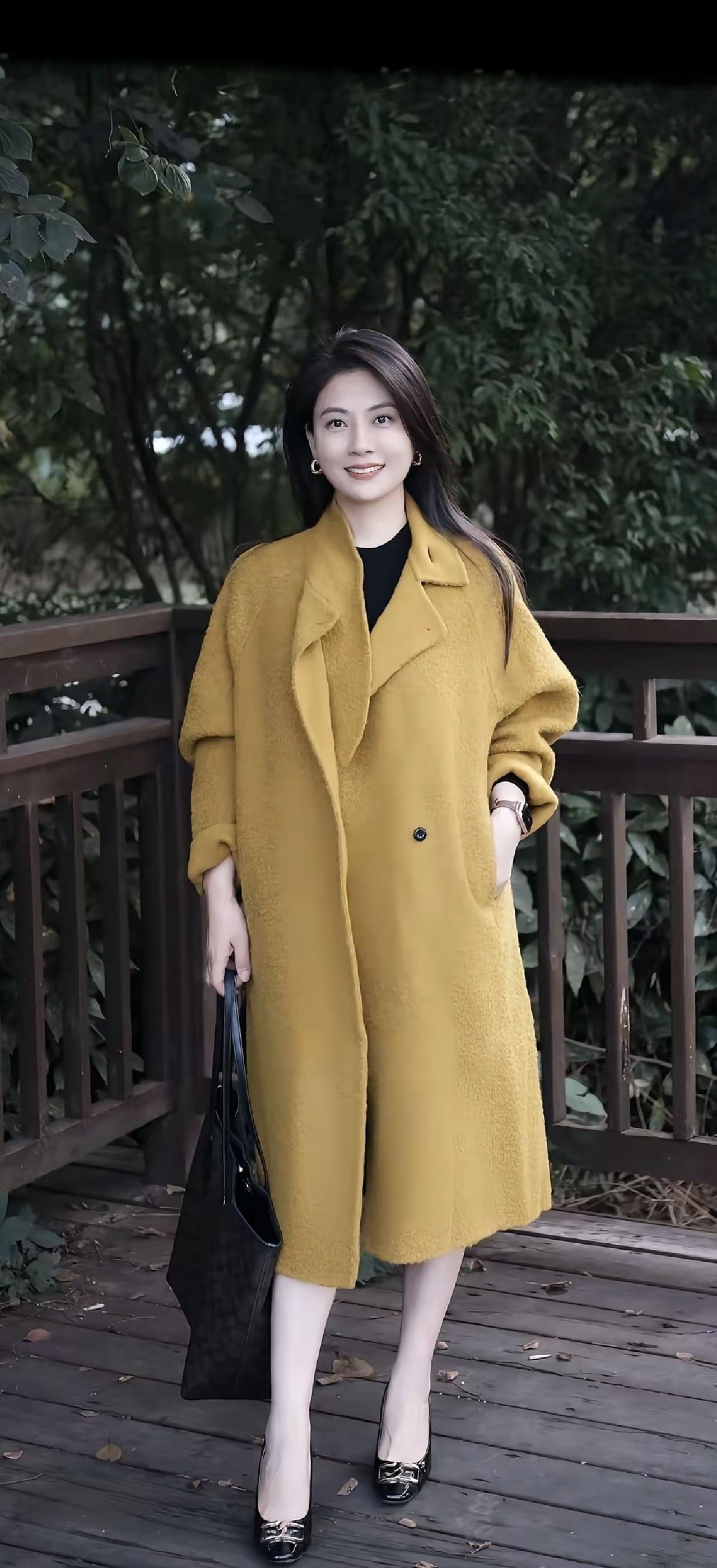 穿黄色大衣的女士在户外拍照。