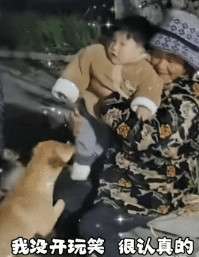 傍晚时候几个大妈聚在一起拉呱，其中花衣服大妈把红衣服大妈的孙子抱了过来，这时红衣