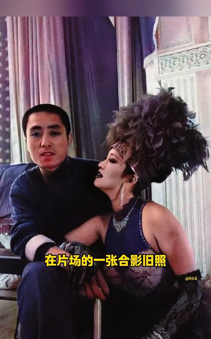 这是张艺谋与巩俐在片场的一张合影旧照。巩俐身上的衣服应该是电影中的服装，非常性感