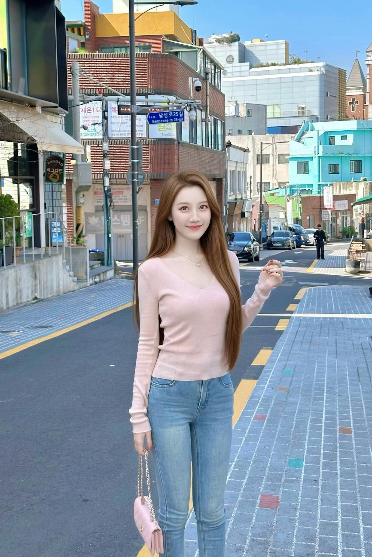 首尔街头的风，带着阳光的温度。浅粉针织衫搭配牛仔裤，把温柔和松弛感都穿在了身上，