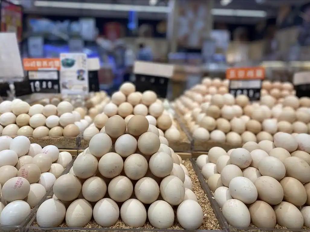 清晨的煎饼果子摊前，大妈熟练地磕开一枚鸡蛋，蛋液滑落在面糊上，散发出诱人的香气。