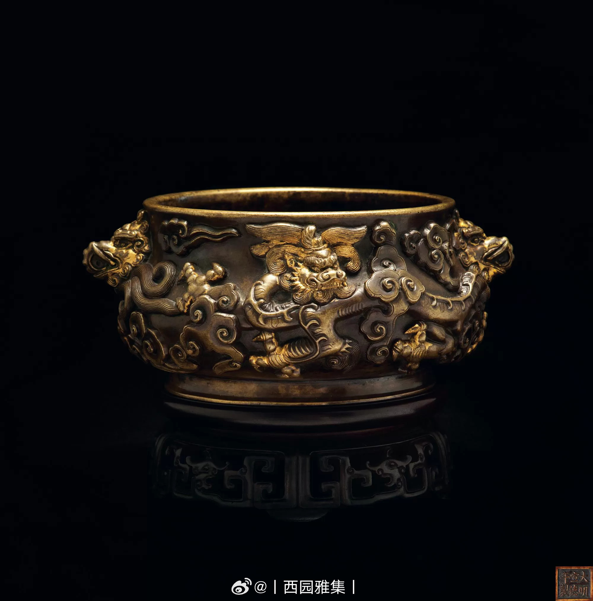 明鎏金浮雕云龙兽耳宣炉鼓腹，下腹圜收，圈足外撇。两铺首为象与饕餮合体而成的异兽