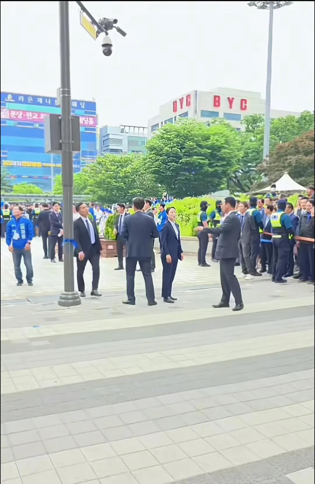 李在明安保队伍里有个女保镖，看起来像是个头目呢。她与人交谈的时候，不停地指来指去