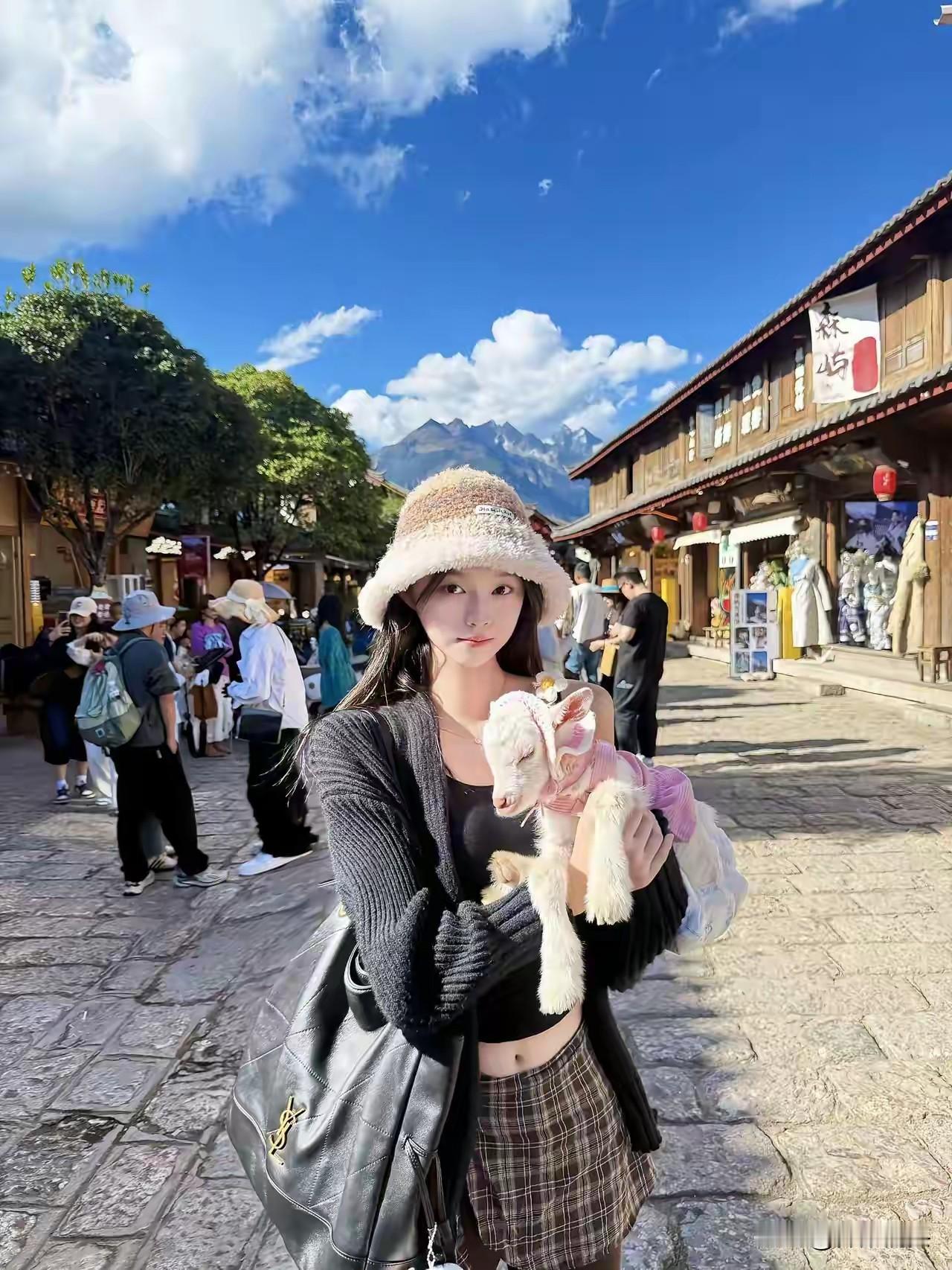 在古镇的阳光下，抱着可爱的小羊，感受生活的美好。