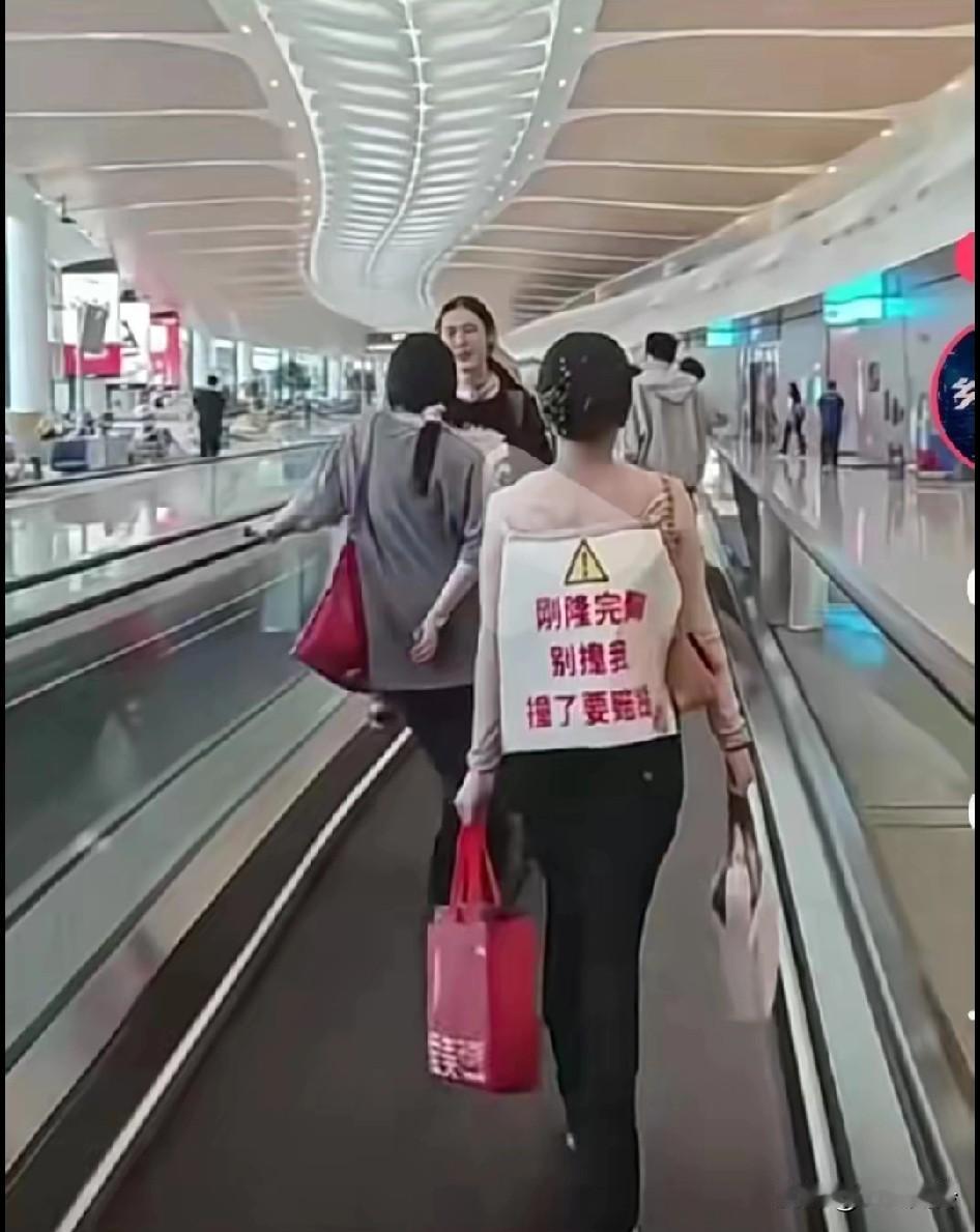 这女子也太敢了哈哈！简直太搞笑了吧？身后挂牌子:刚隆完胸，别撞我，撞我撞坏了，