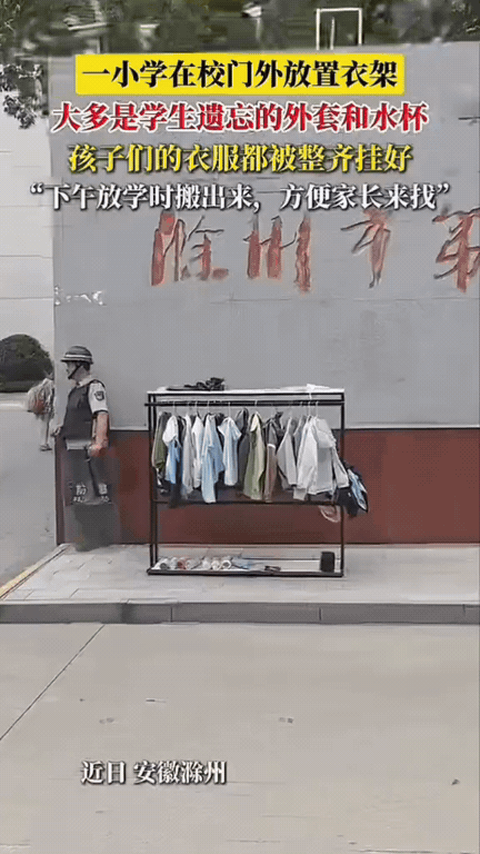 小细节太戳人！一小学每到放学时间，保安师傅就会搬出一个衣架摆在校门口，上面衣服、