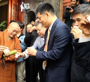 这是释永信给信徒与游客倒水。这应该不是一般的水。水被装在精致的竹筒里。每人都手持