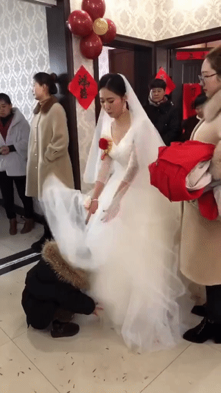 这个新娘子可真有意思。她在等待新郎过来接亲的时候，竟然逗起了旁边的小孩？