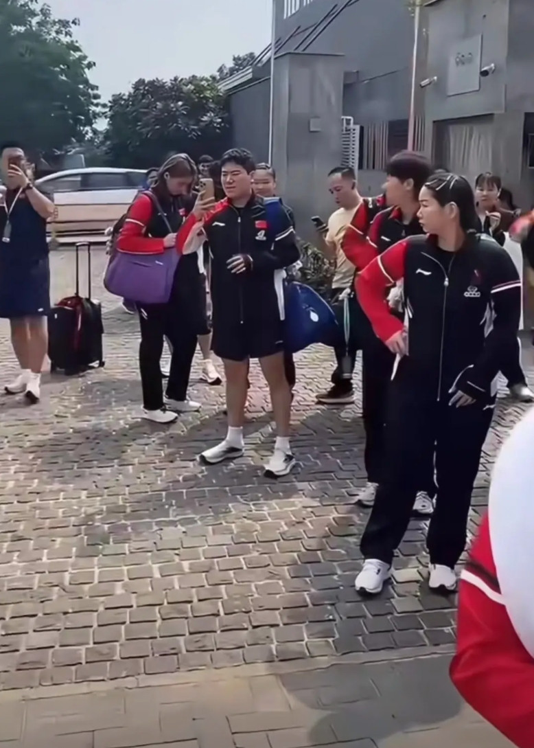 正在印度举行的乒乓球亚锦赛，国乒队员们站在酒店门口等车，看着路边的环境，有的在拿