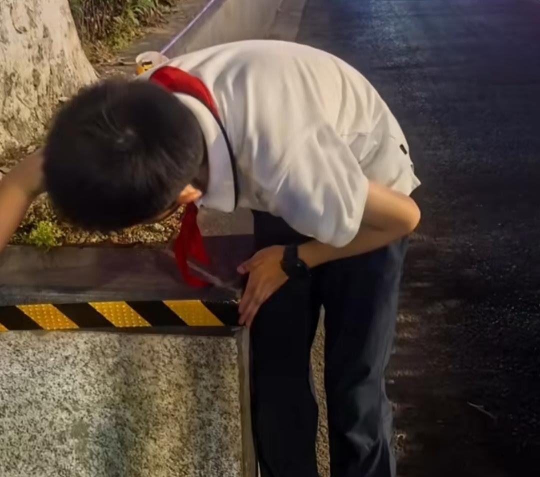 南京的夜晚，路灯的光晕洒在湿漉漉的路面上，南师附小的曹骏熙背着书包，正弯腰为路边