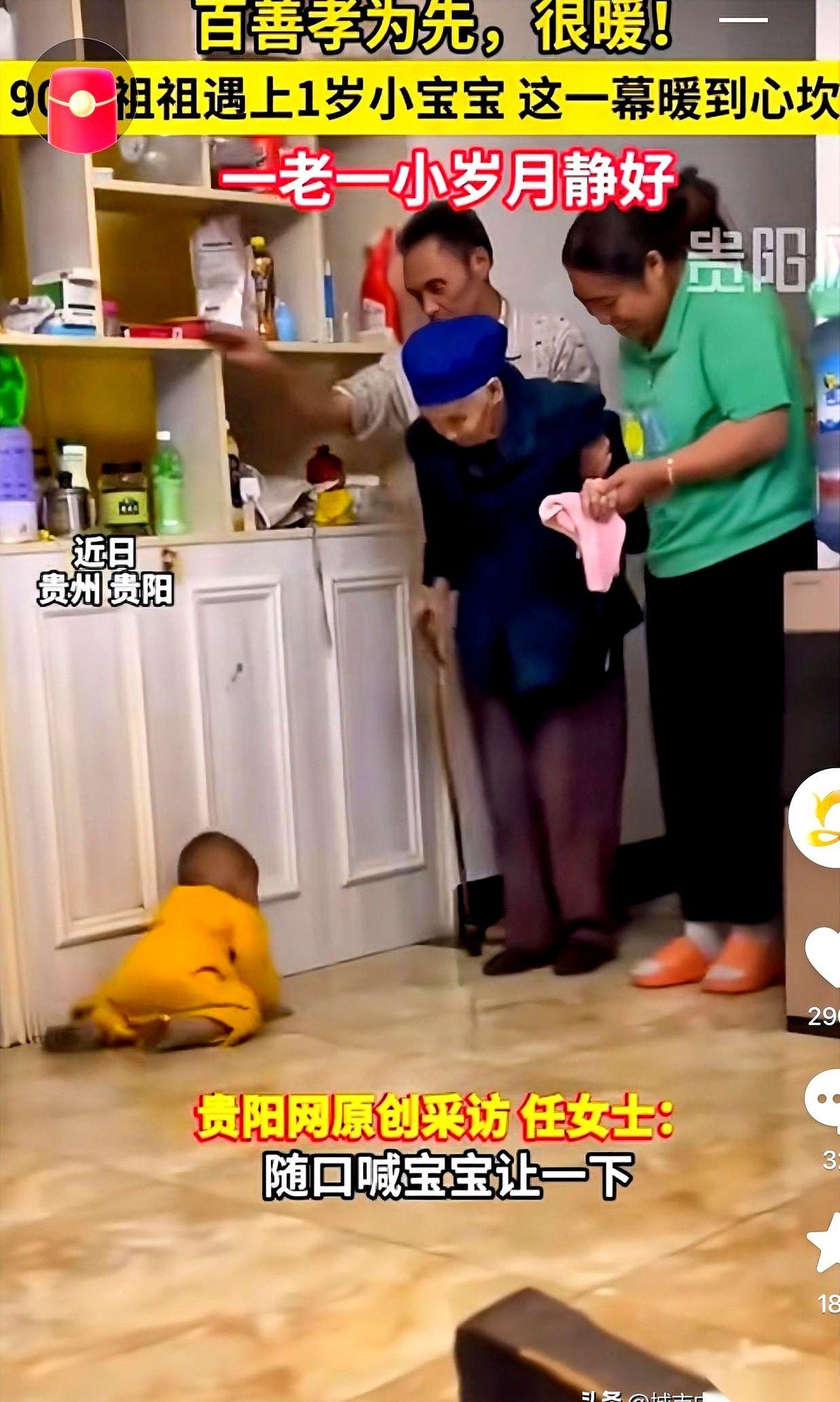 在贵州贵阳，一个一岁的小宝宝在地上向后倒退着爬，给90岁的祖祖腾出了走路的道。