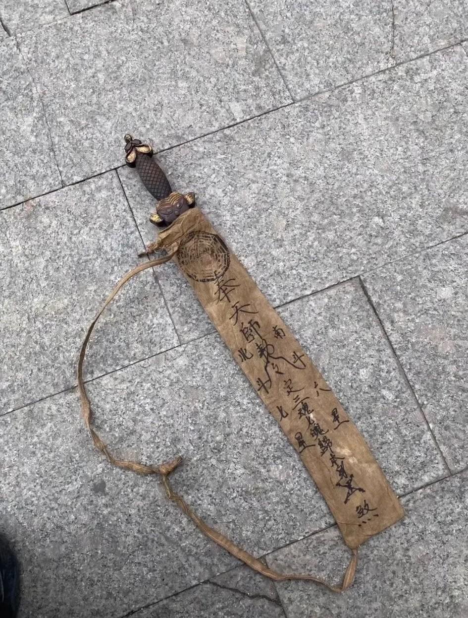 隔壁邻居从老宅中翻出一把古剑！看样子有些年头了，剑袋上还写着文字和符咒，看上去颇