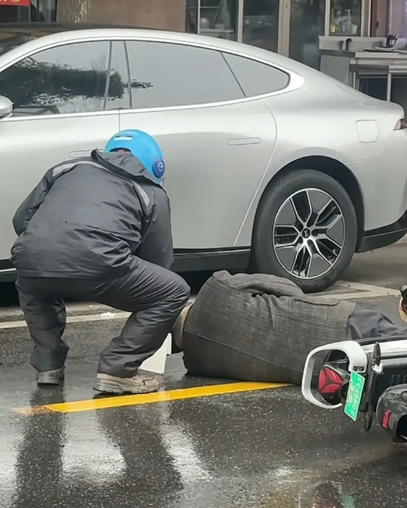 今天（2月11日），扬州高邮宋庄路发生了一起交通事故。雨天的马路上躺着一位大爷，