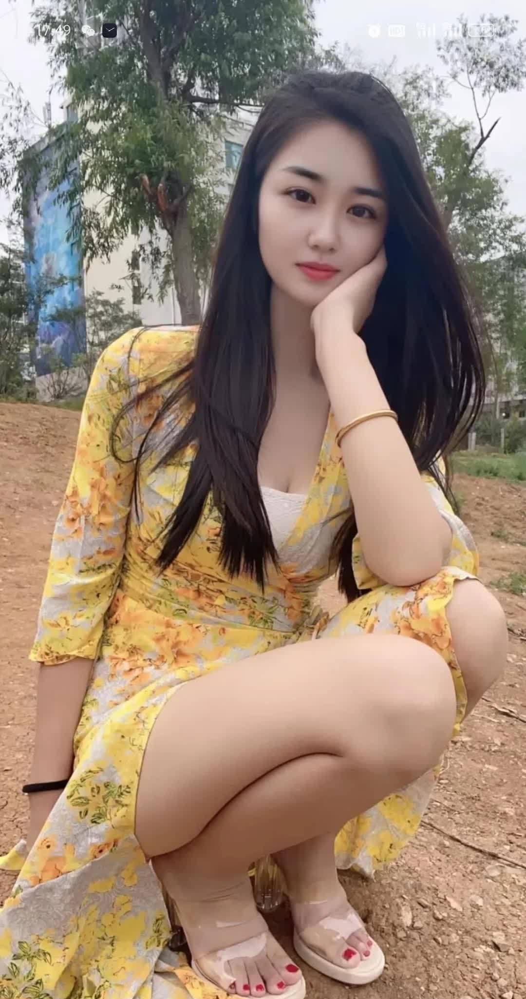 蹲在土路上，黄色花裙，白底红花，手托脸蛋，红指甲，白凉鞋，自然风，清新美。