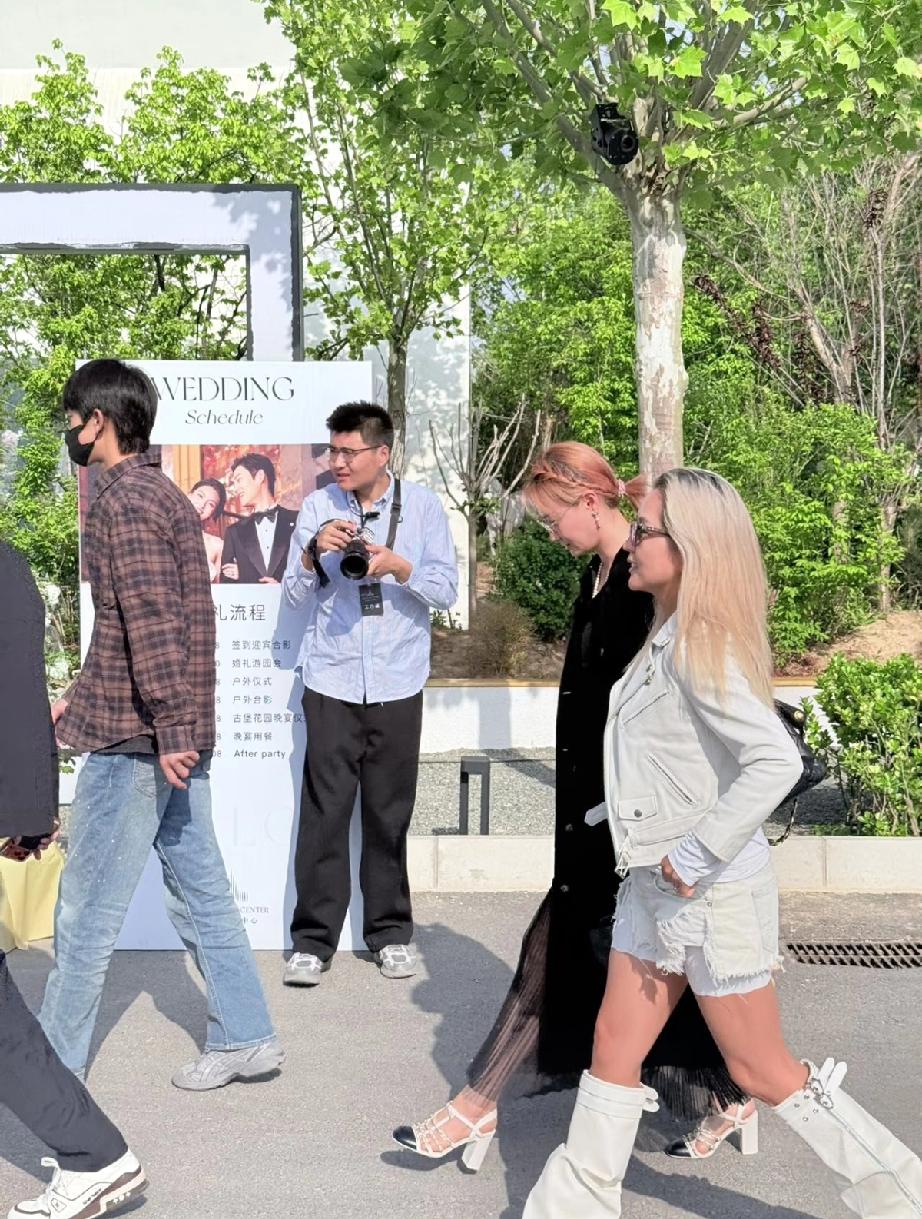 4月23日，何洁北京参加朋友婚礼，无修图下好黑，个子不高腿粗挺拽的，竟然翘着二郎