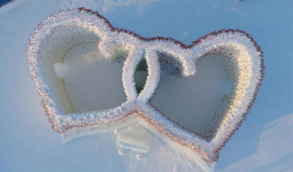 哈尔滨冰雪大世界冰瀑玫瑰“美到犯规”，航拍视角玫瑰从冰墙长出，大批游客前来打卡，