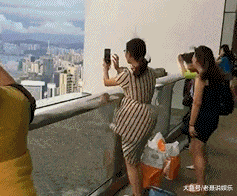 搞笑GIF: 妹子登高拍风景, 奈何大风不正经