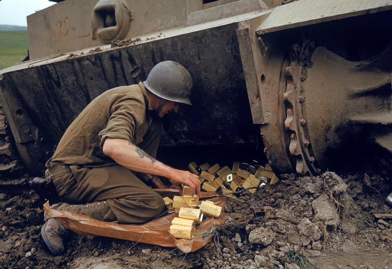1943年4月，一名美国陆军工兵在北非突尼斯亨特峡谷附近整理TNT炸药罐，旁边是
