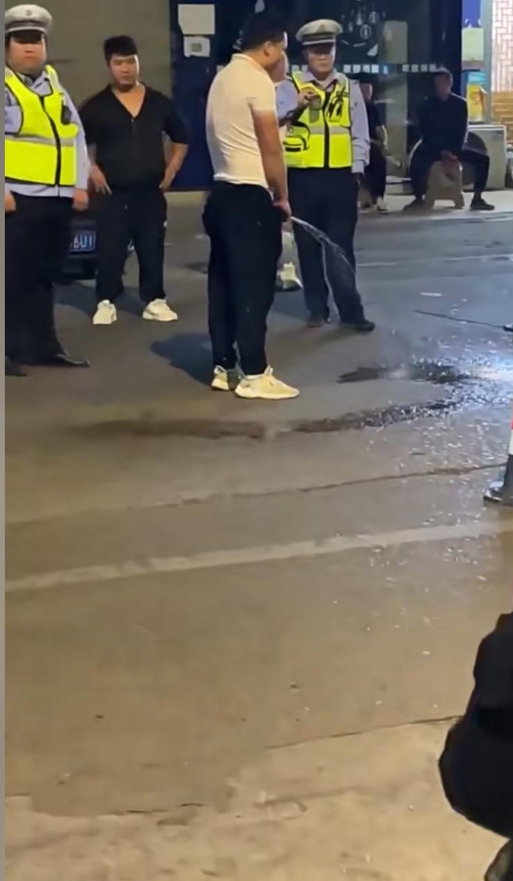 本来交警拦下来查酒驾，白衣服大哥灵机一动，当场在路边放水，本想着借着上尿开溜。