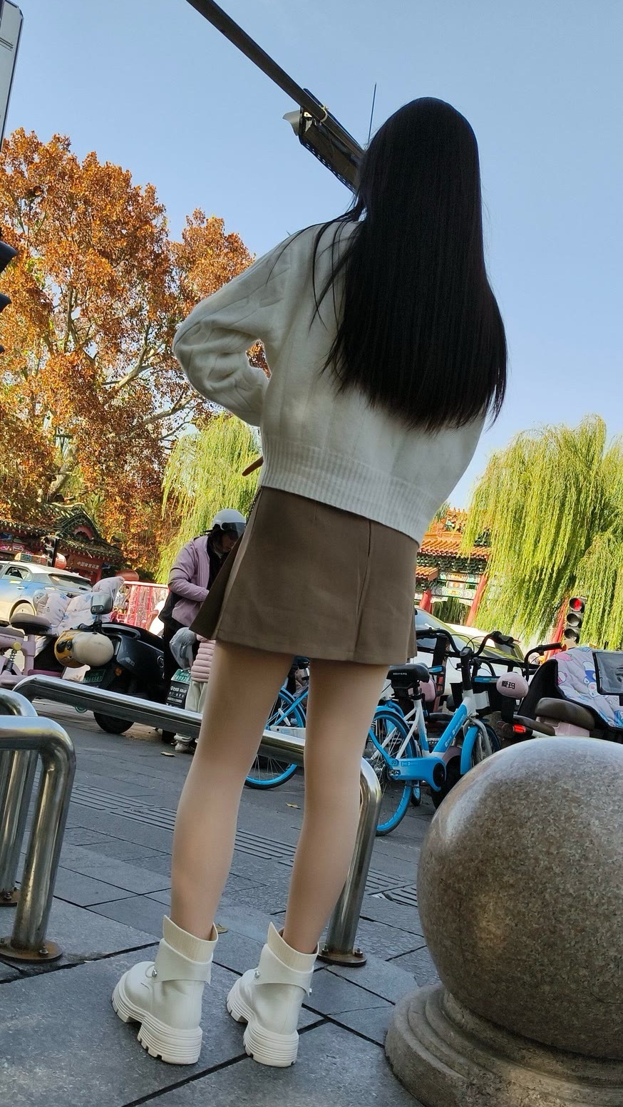 米白色绞花针织开衫，搭配卡其色皮质百褶短裙，脚踩白色厚底马丁靴，造型休闲又不失时