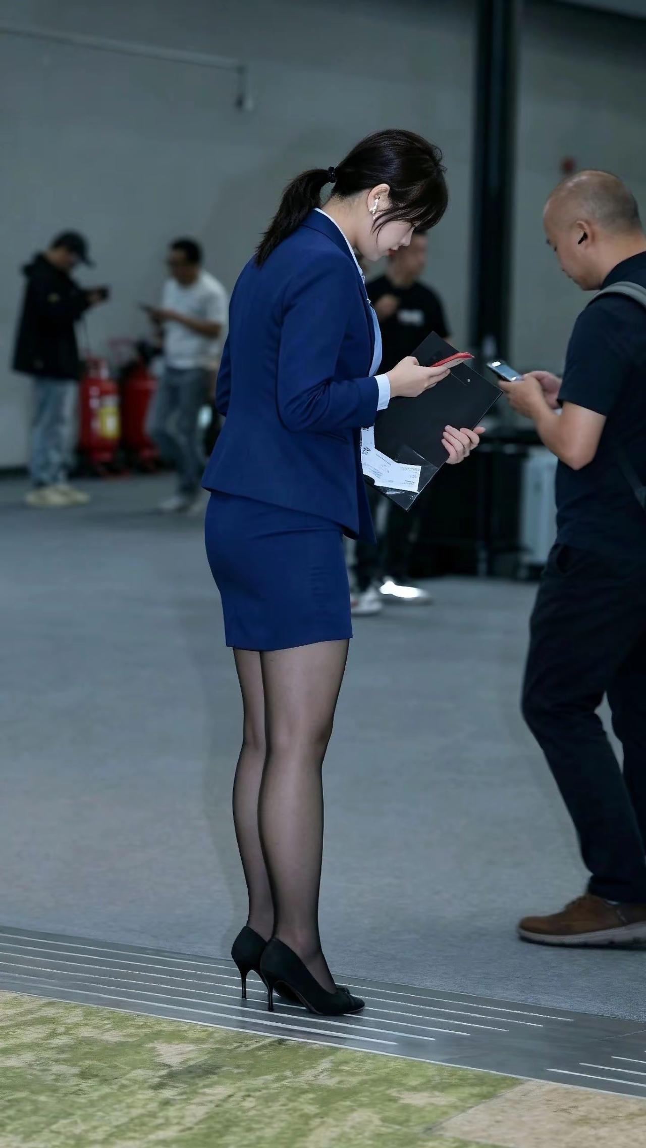 一位穿蓝色套装的女士在看文件。
