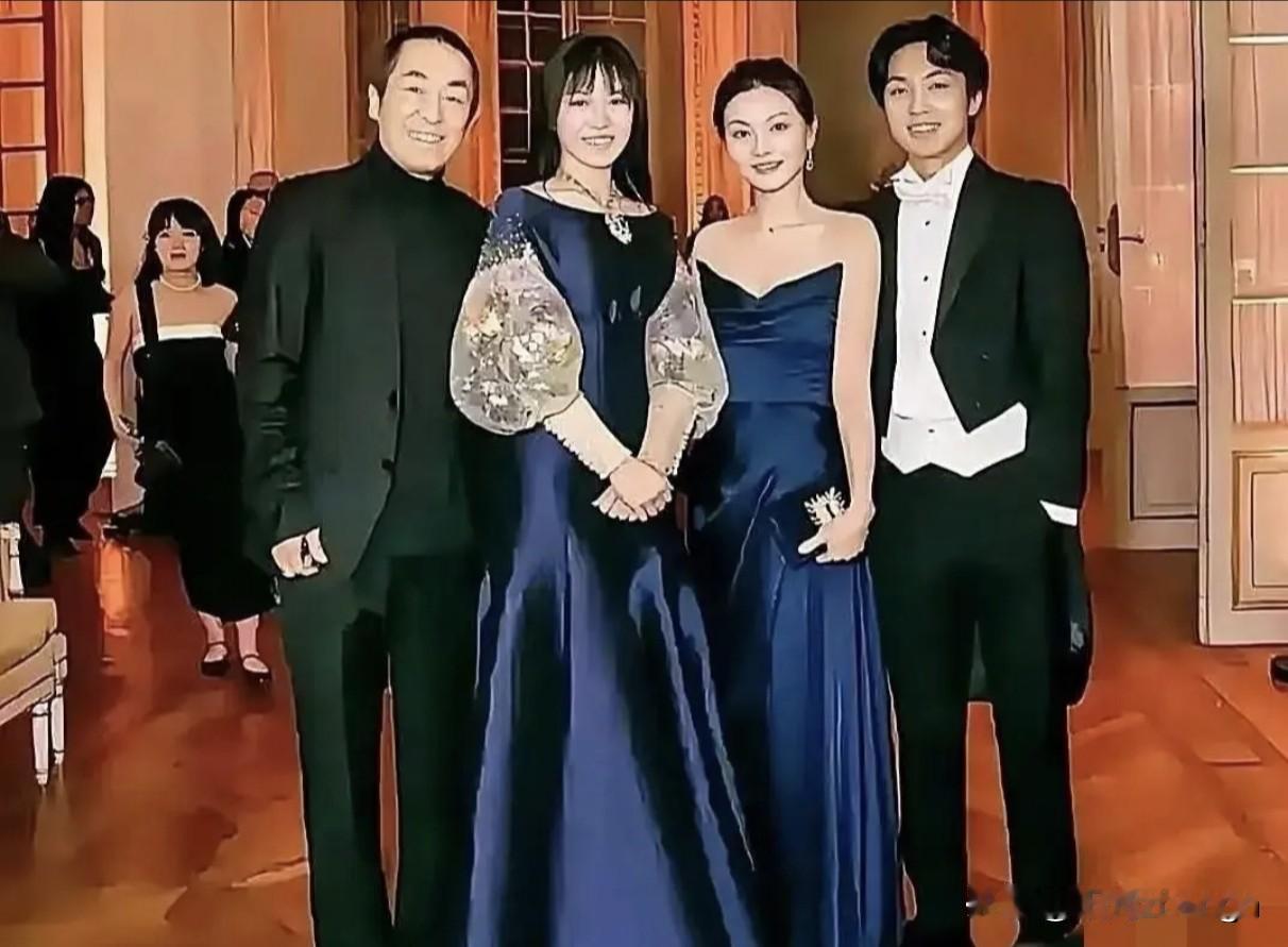 张艺谋一家四口整整齐齐地站在一排，看起来特别有爱。张艺谋穿着整洁大方，气质沉
