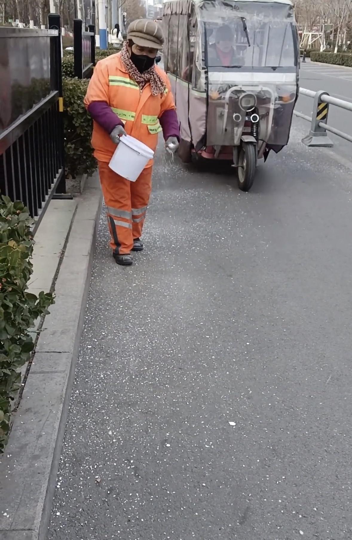 河南大雪即将登场，清洁工阿姨在为融雪做准备，大雪还未满来融雪剂已撒在路上，即时为