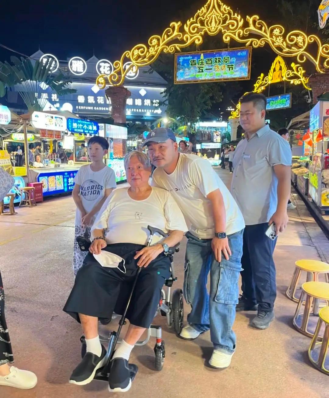 洪金宝和家人到西双版纳旅游，坐着轮椅逛夜市，身材肥胖变化好大！​​​