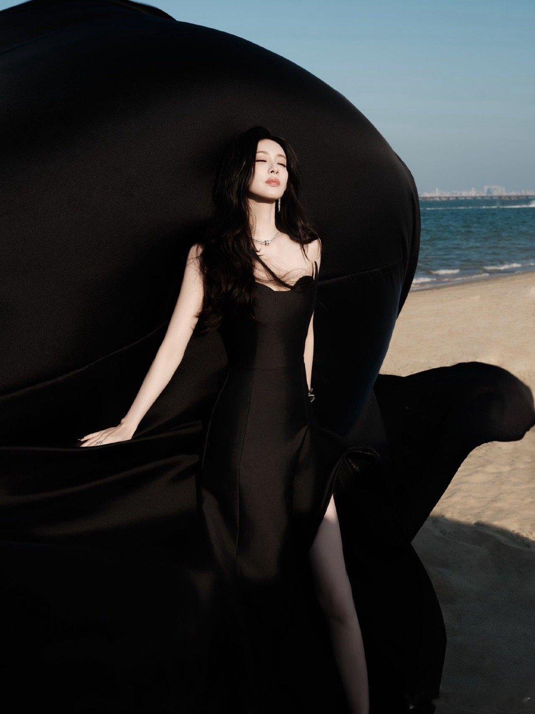 孟子义黑裙天使翅膀海边吹来暗夜浪漫！黑裙造型勾勒曼妙身姿，天使翅膀点缀梦幻氛围