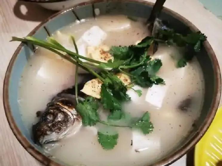 餐桌上三道家常菜错落摆放，每一道都色香味俱佳，暖意扑面而来。清炖鲫鱼汤色奶