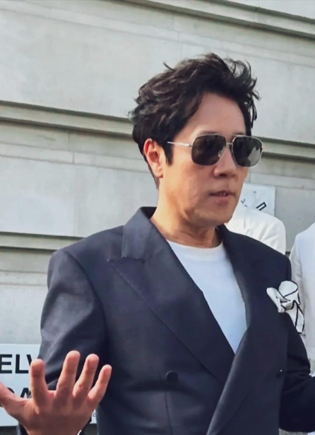 蔡国庆白体恤外面穿西服，穿一双黑色绣着白花的鞋子，这一身打扮不伦不类。看着也不年