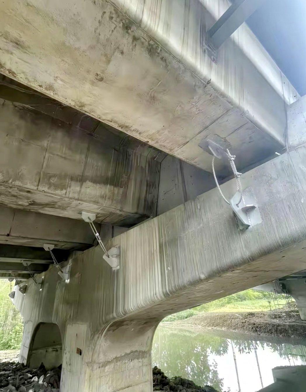 在横跨水面的混凝土桥梁主梁之间，通过钢索、金属板及锁具构成的装置相互连接。我想打