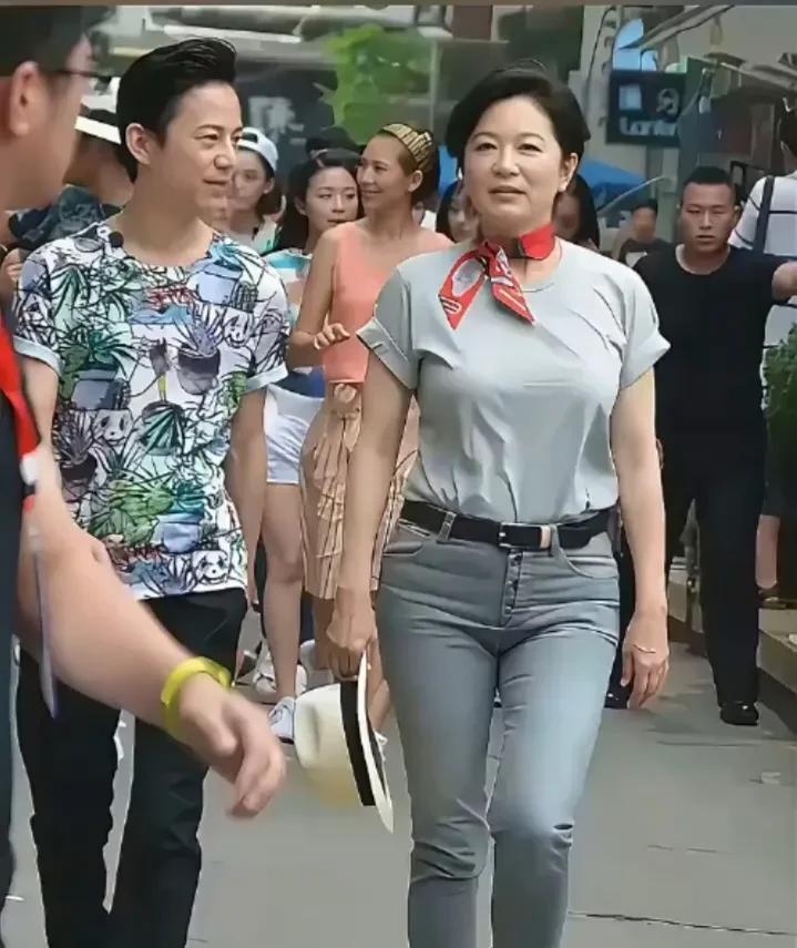 这是著名影星林青霞，和央视主持人何炅并肩同行的画面。林青霞虽年近70岁，长何炅2