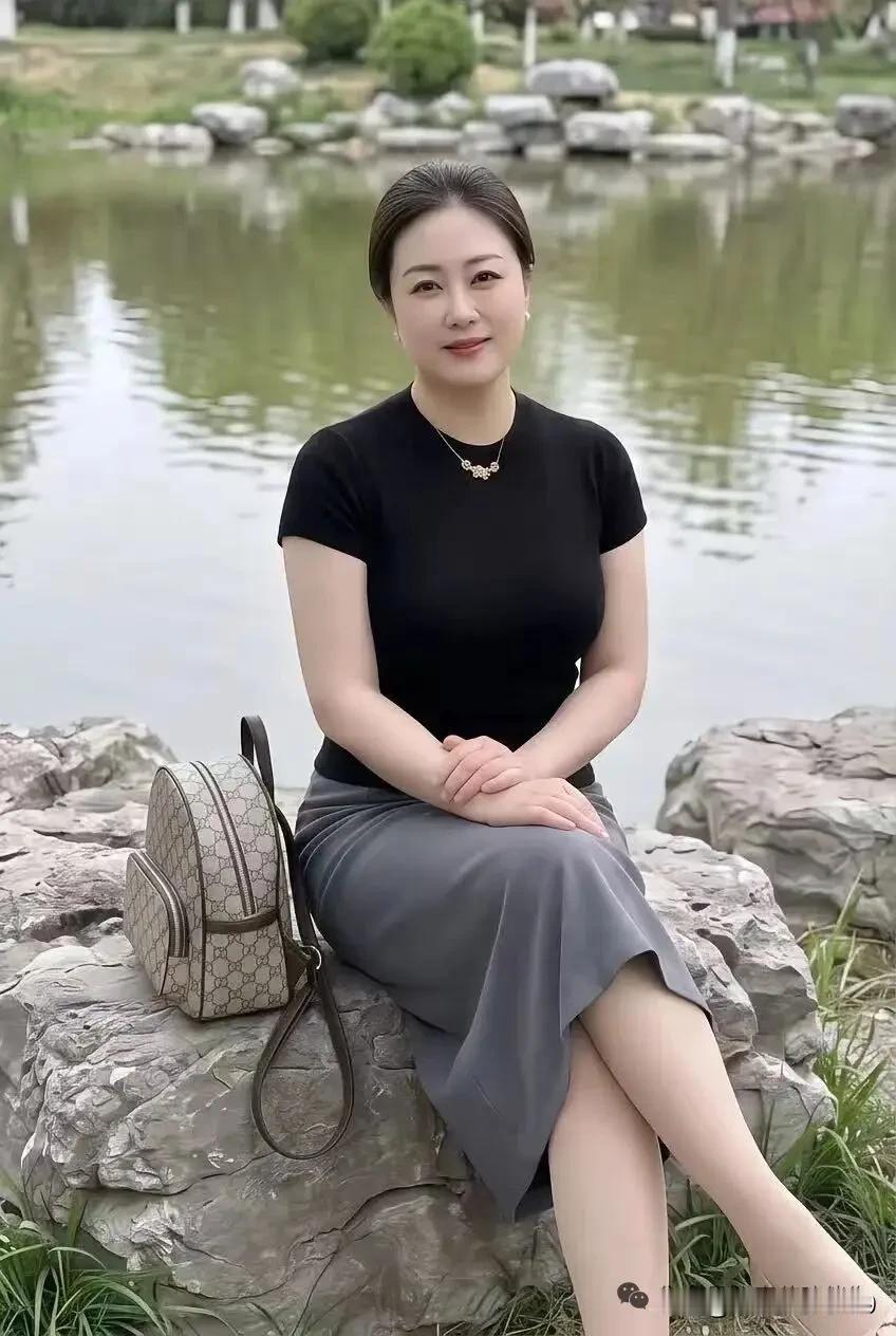 湖边少妇悠然自得的模样，着实令人羡慕。她微笑着凝视前方，不知在思索什么。或许是生
