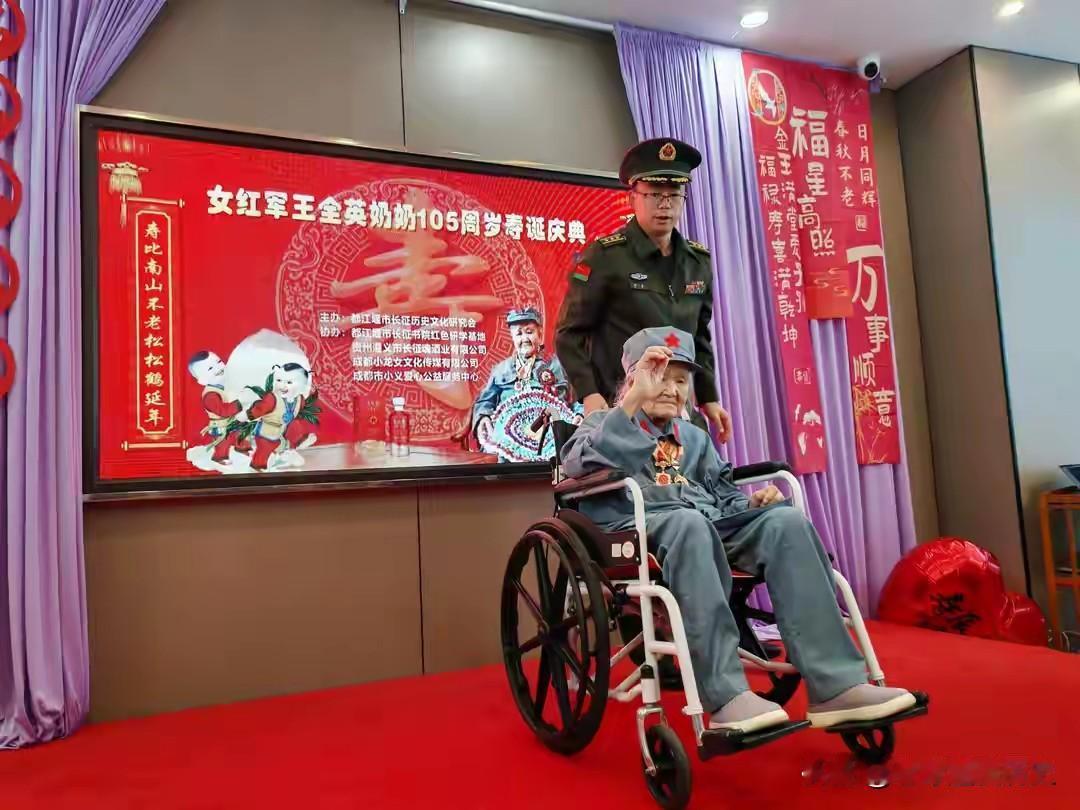 这场寿典定格了百岁女红军王全英105岁的珍贵时刻。老人端坐在轮椅上，身着复刻的