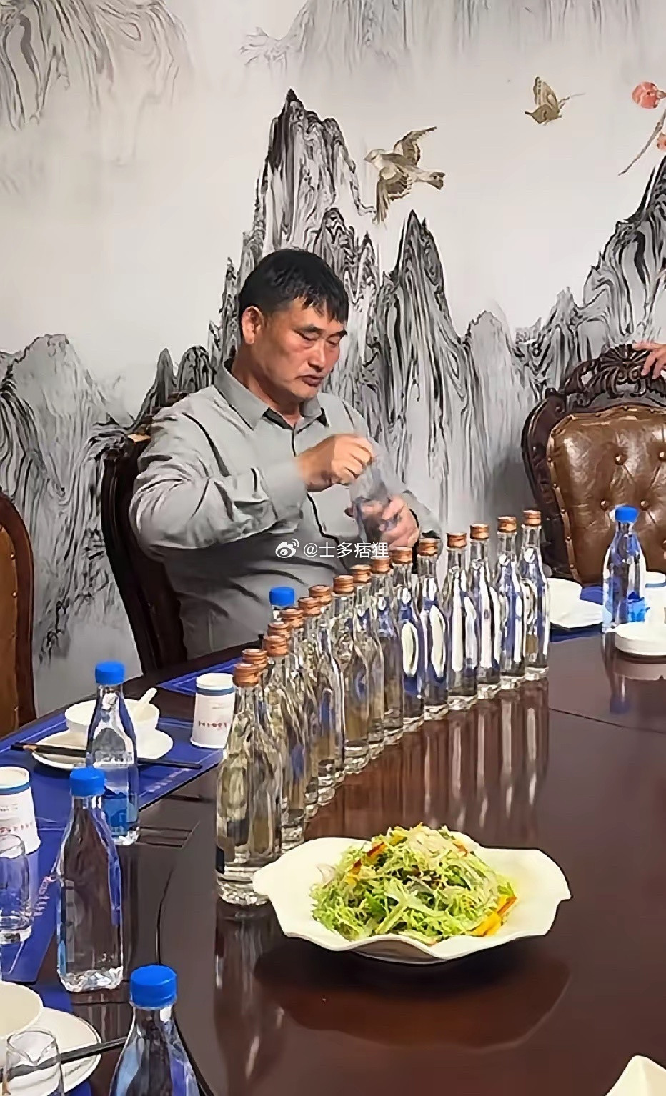 大衣哥演出结束后，受邀与友人们聚餐时的一幕，面前放满了光瓶白酒