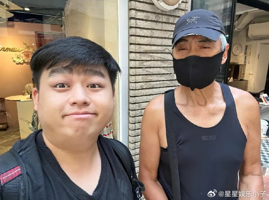 70岁周润发现身香港i街头，他穿着老头背心和紧身裤，背着大包，朴素里面带着一丝土