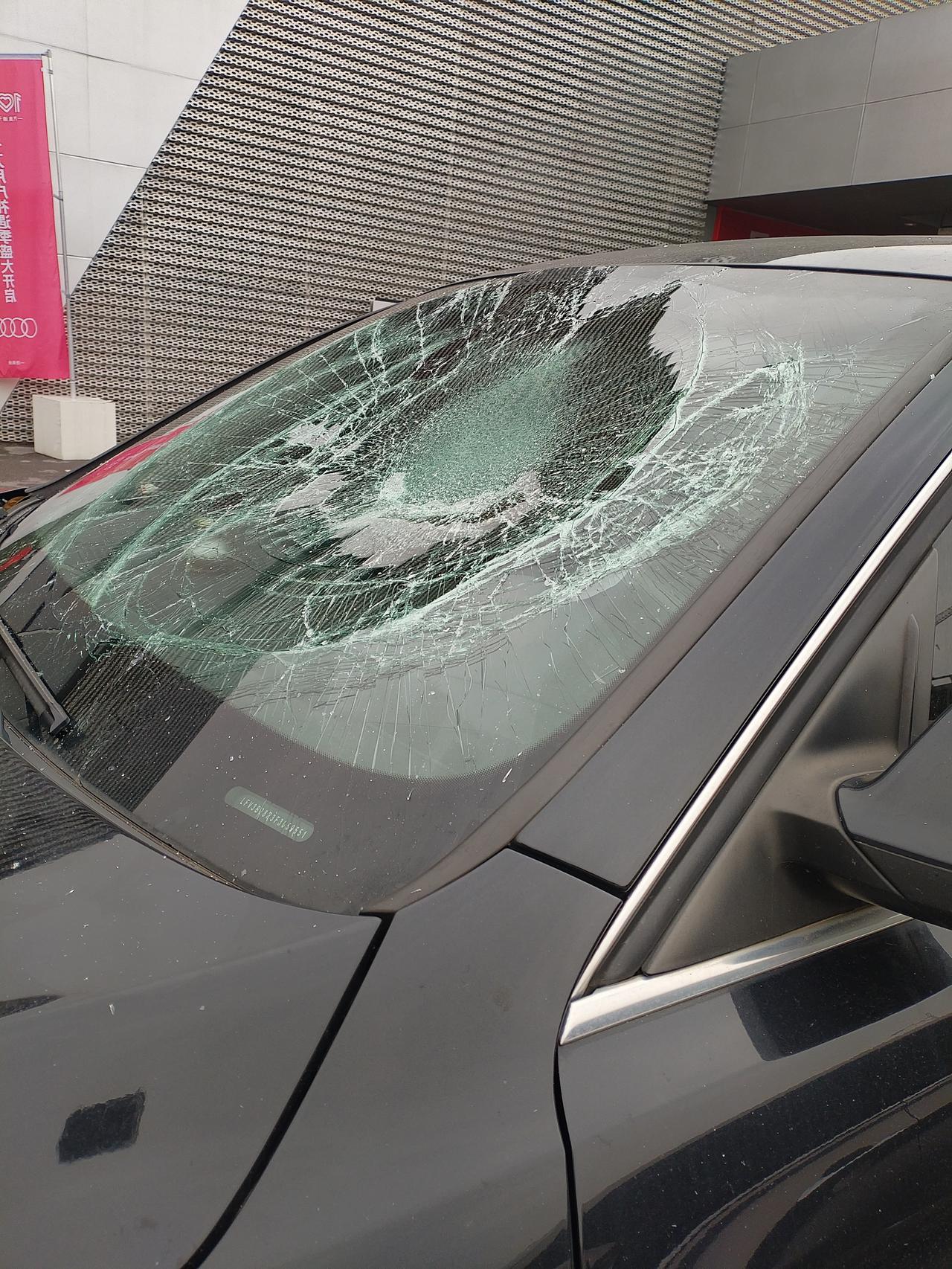 前挡风玻璃破碎成了蛛网，还被猛烈撞击出一个大坑。所幸贴的膜质量上乘，玻璃与膜虽已