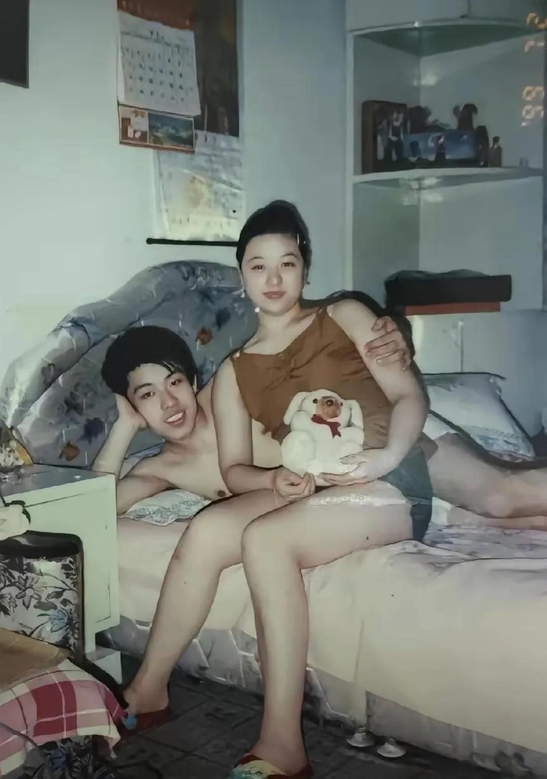 这是九十年代一对年轻人在家拍下的照片。没有精致的布景，没有华丽的衣服，男孩随意