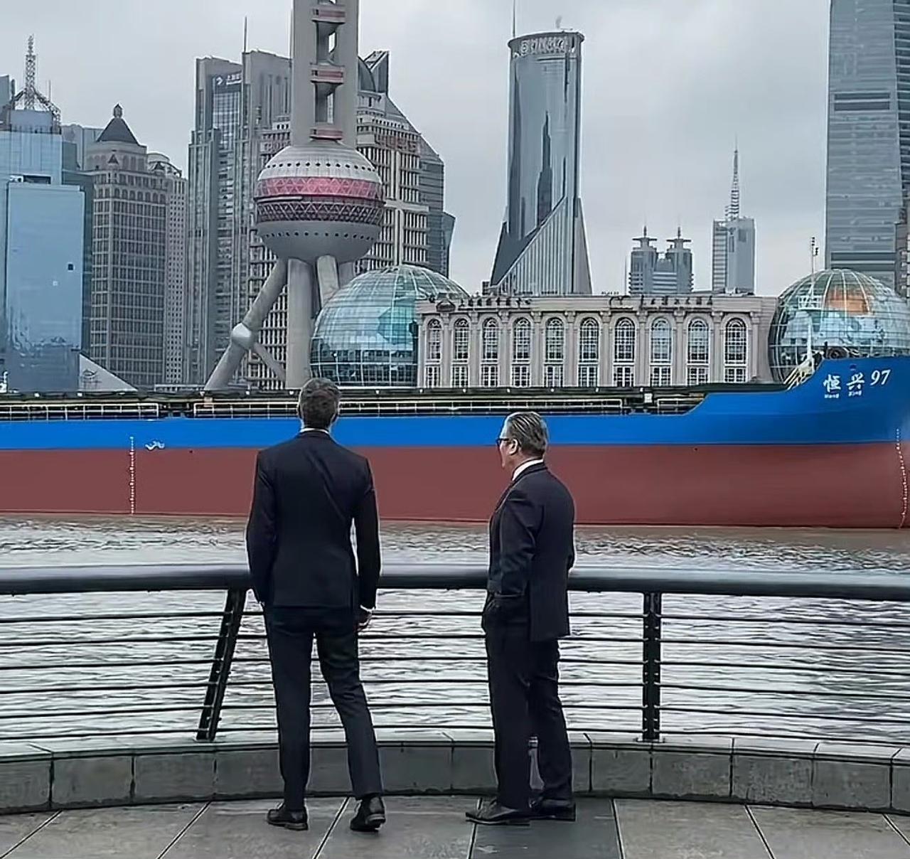 这是一张英国斯塔默访沪时拍摄的照片，他站在黄浦江边，眺望着浦东的高楼大厦以及东方